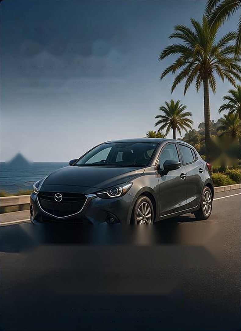 Grey Mazda Demio on a seaside road with palm trees